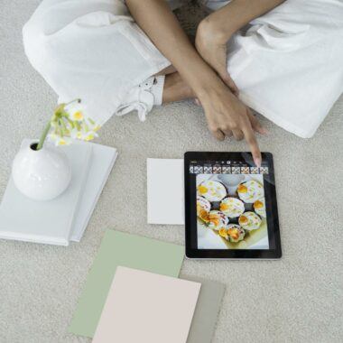 Young woman using a tablet in a modern, minimalist workspace with pastel decor.