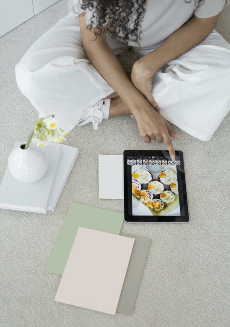 Young woman using a tablet in a modern, minimalist workspace with pastel decor.